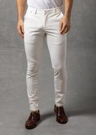 Man wearing a white t-shirt and pants against a gray background